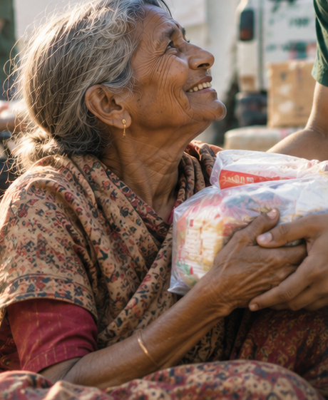An elderly woman smiling as she receives a relief kit