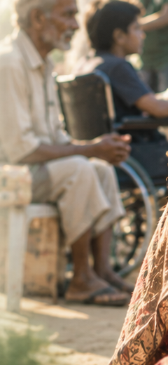An elderly man and a child in a wheelchair at a relief camp